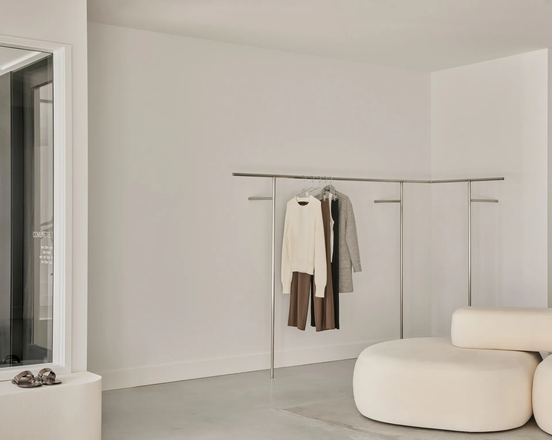 Minimalist clothing showroom with neutral tones and modern design.