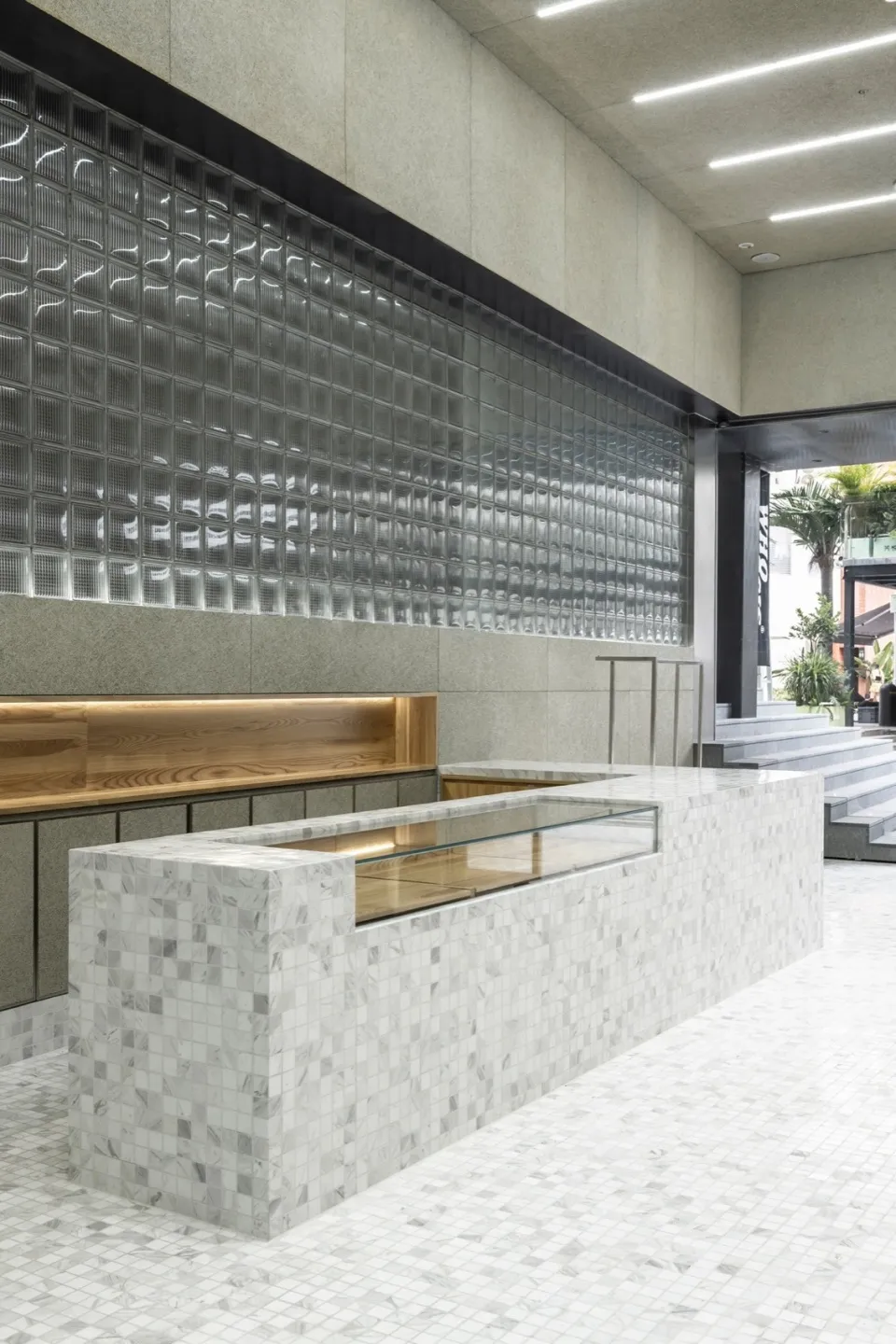 A modern restaurant counter with a marble facade and glass display case.