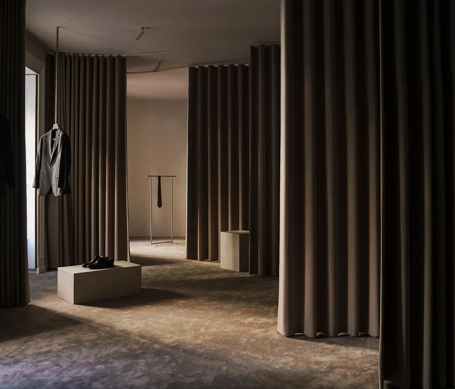 Clothing retail space featuring fabric curtains and shelving
