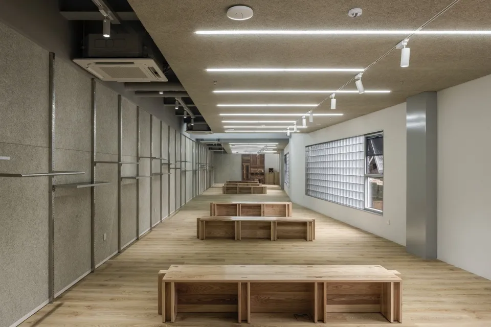 現代辦公空間，展現木質長椅與混凝土牆面