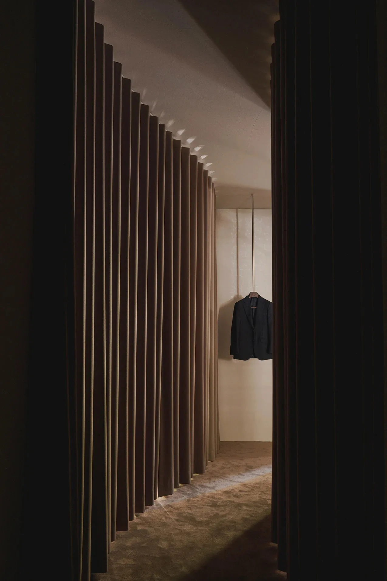 A minimalist fashion shop with a single clothes hanger displaying a suit.