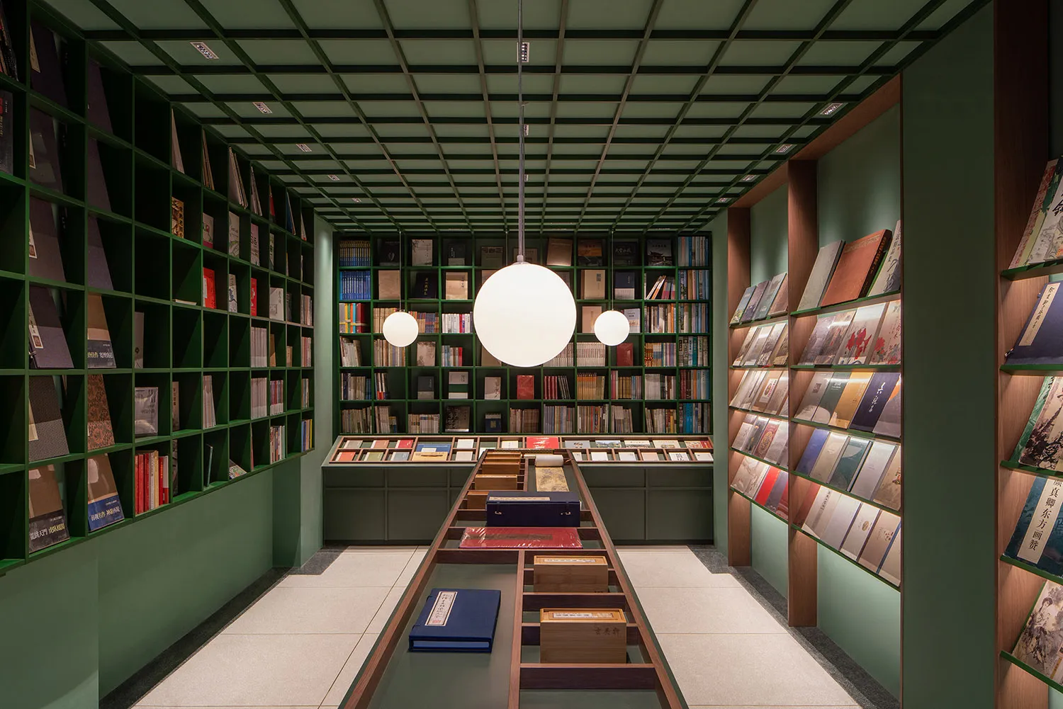 Modern bookstore interior with glass shelves, wooden display cases, and metal accents.