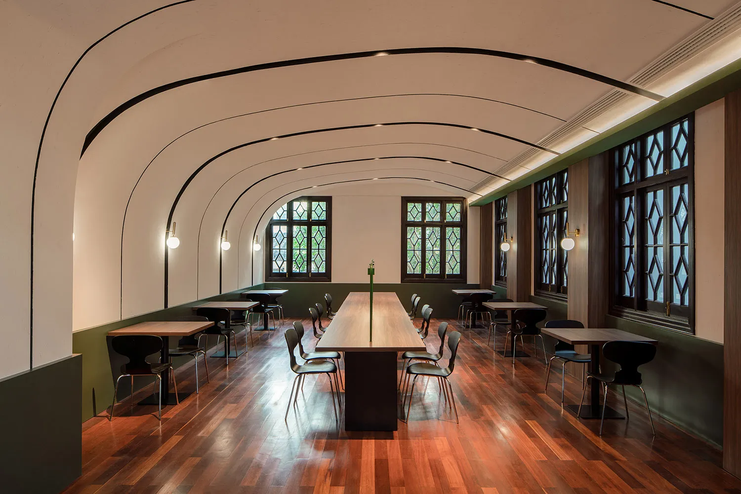 現代自助餐廳內設有木質桌椅,搭配大型窗戶與曲面天花板及嵌入式燈光。