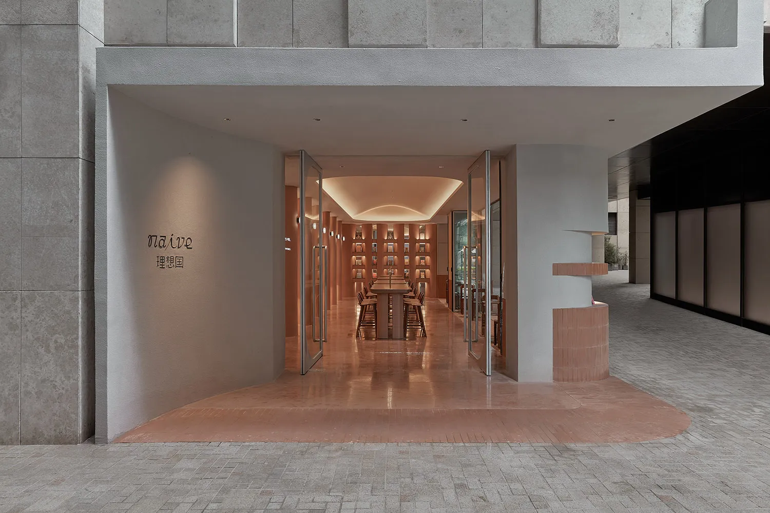 A minimalist retail storefront with concrete walls and lighting.
