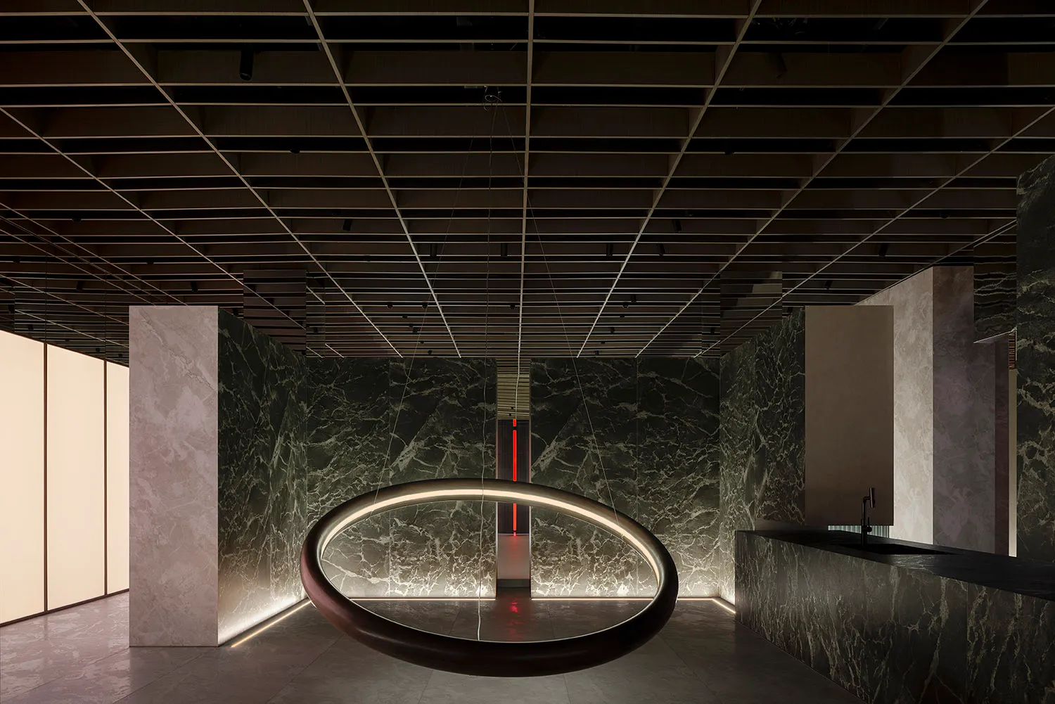 A modern public space featuring marble walls and lighting.