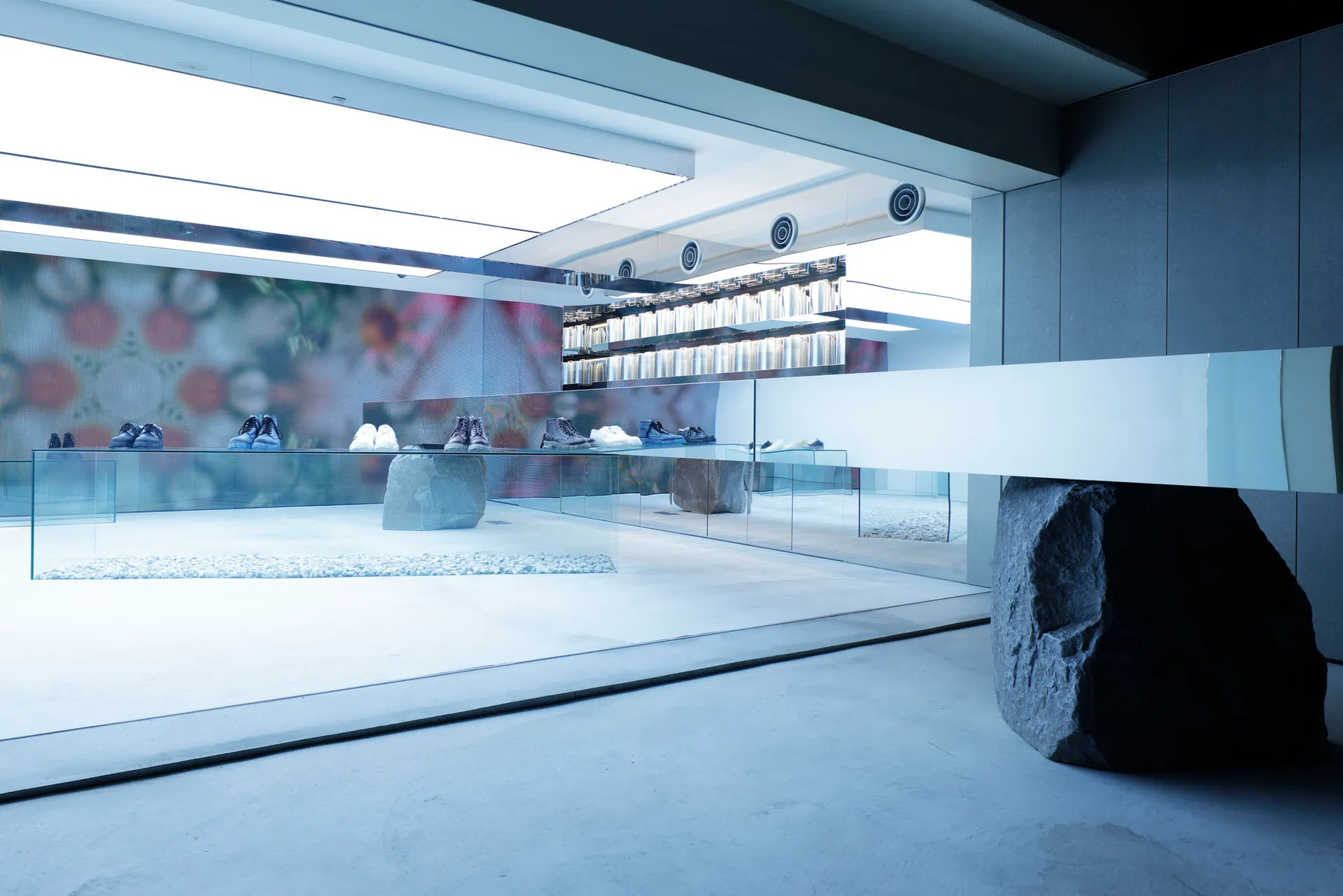 A minimalist retail storefront with glass walls and a polished concrete floor.