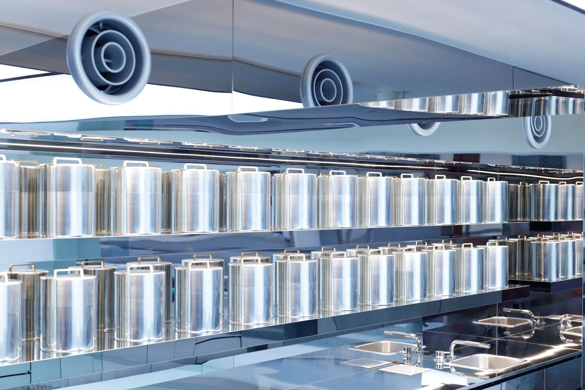A modern kitchen with a wall of aluminum containers.