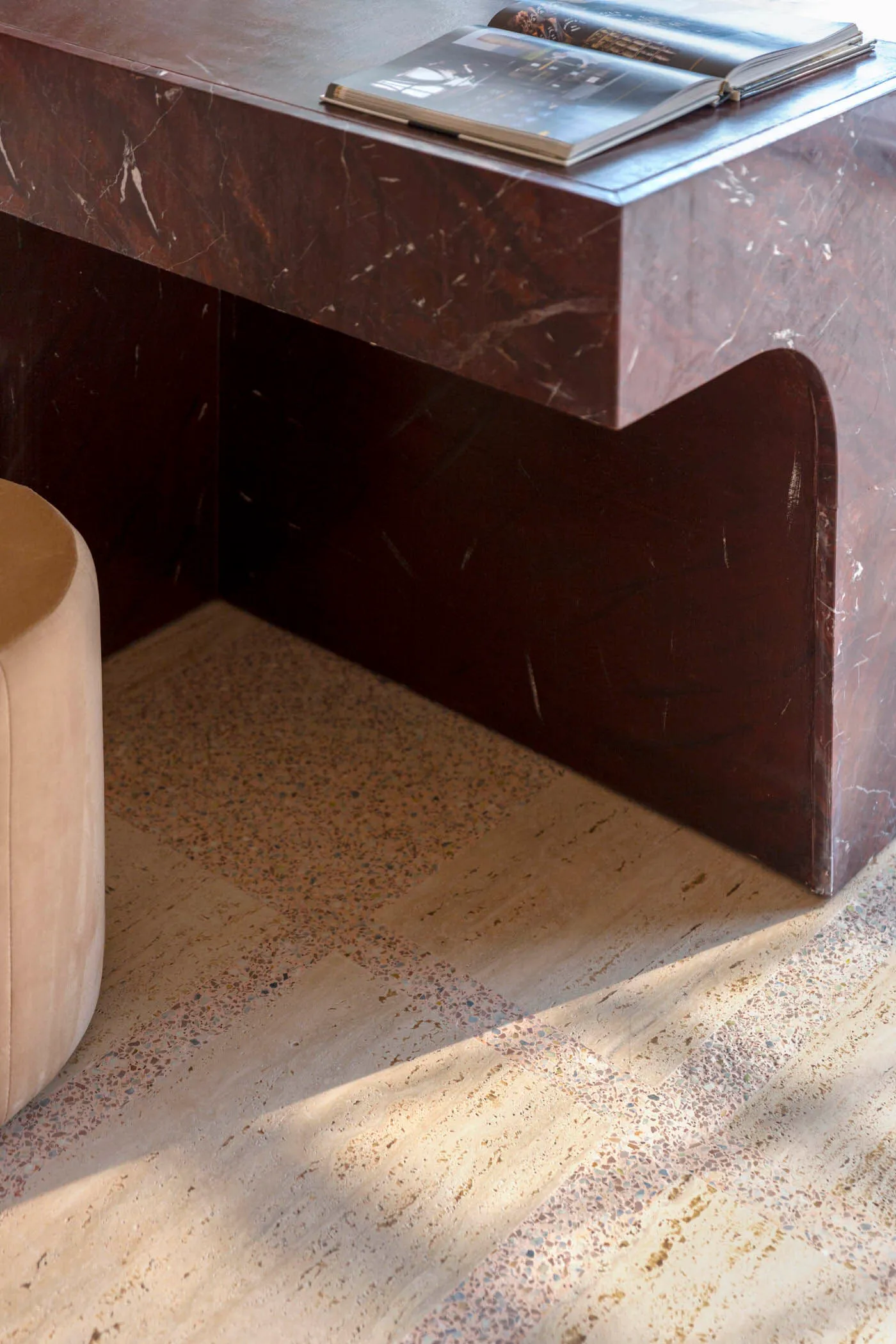 A modern, minimalist desk made of marble with a book on top.