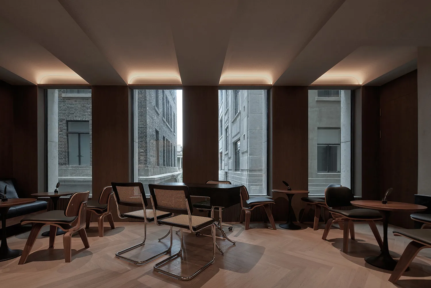 Modern office cafe space with wooden furniture and concrete columns.