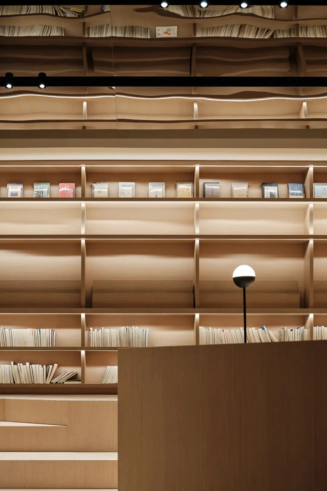 現代圖書館內木質書架上擺滿書籍。