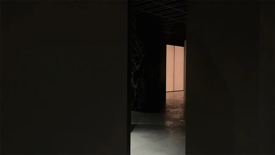 A minimalist, modern indoor passage with concrete walls and floor.