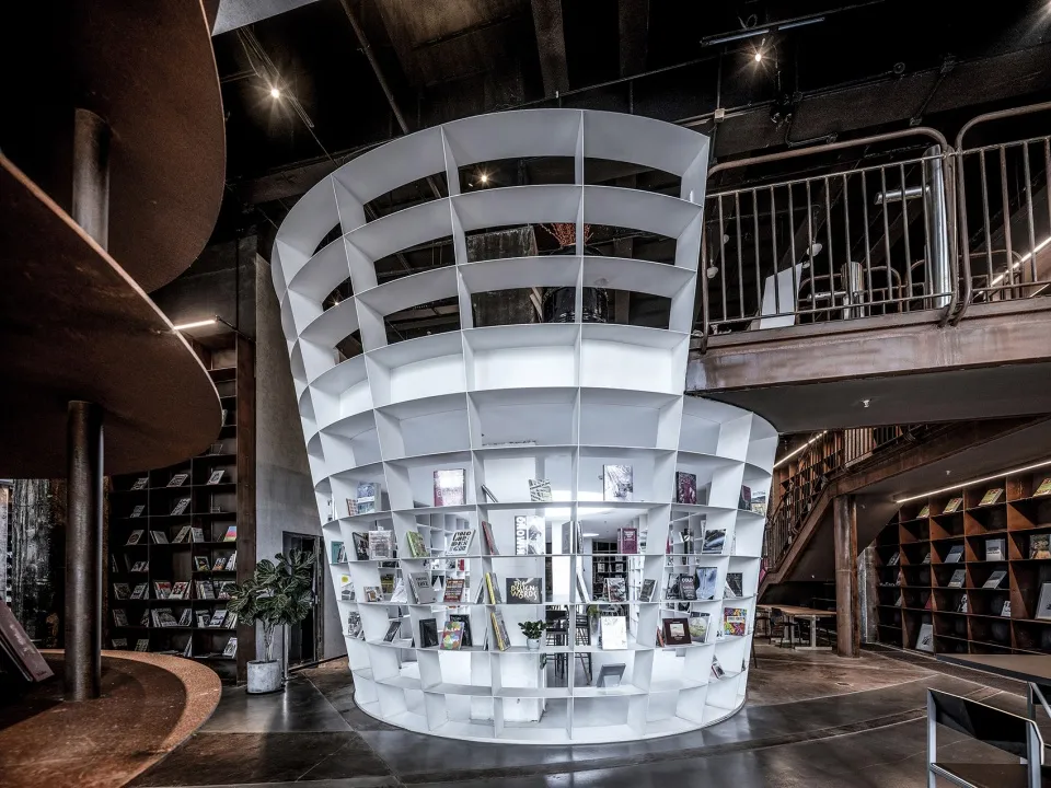 現代圓形金屬牆板圖書館,設有樓梯與多處座位區。