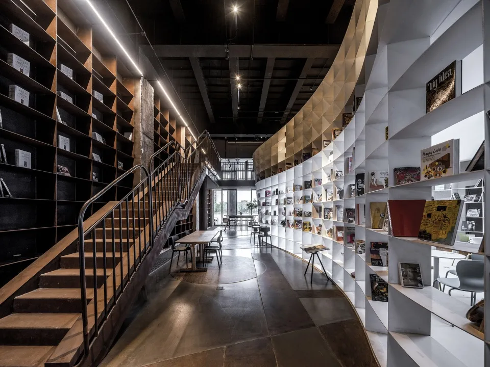 Interior view of a modern library with wooden shelves and tables.