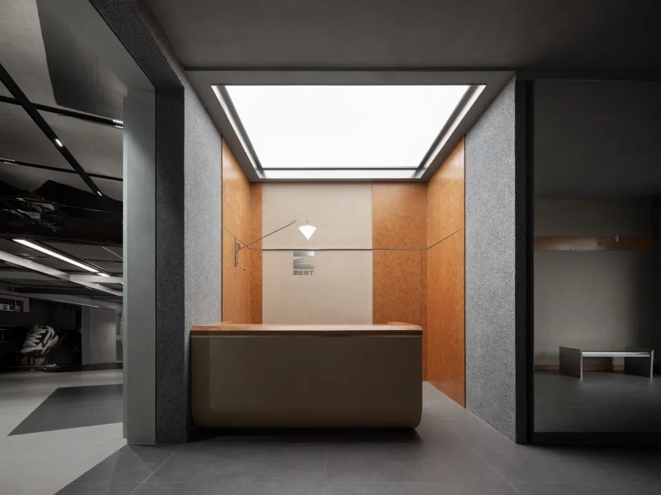 A modern, minimalist reception desk with a concrete finish and sleek lines, featuring a single light source and a clean, unad