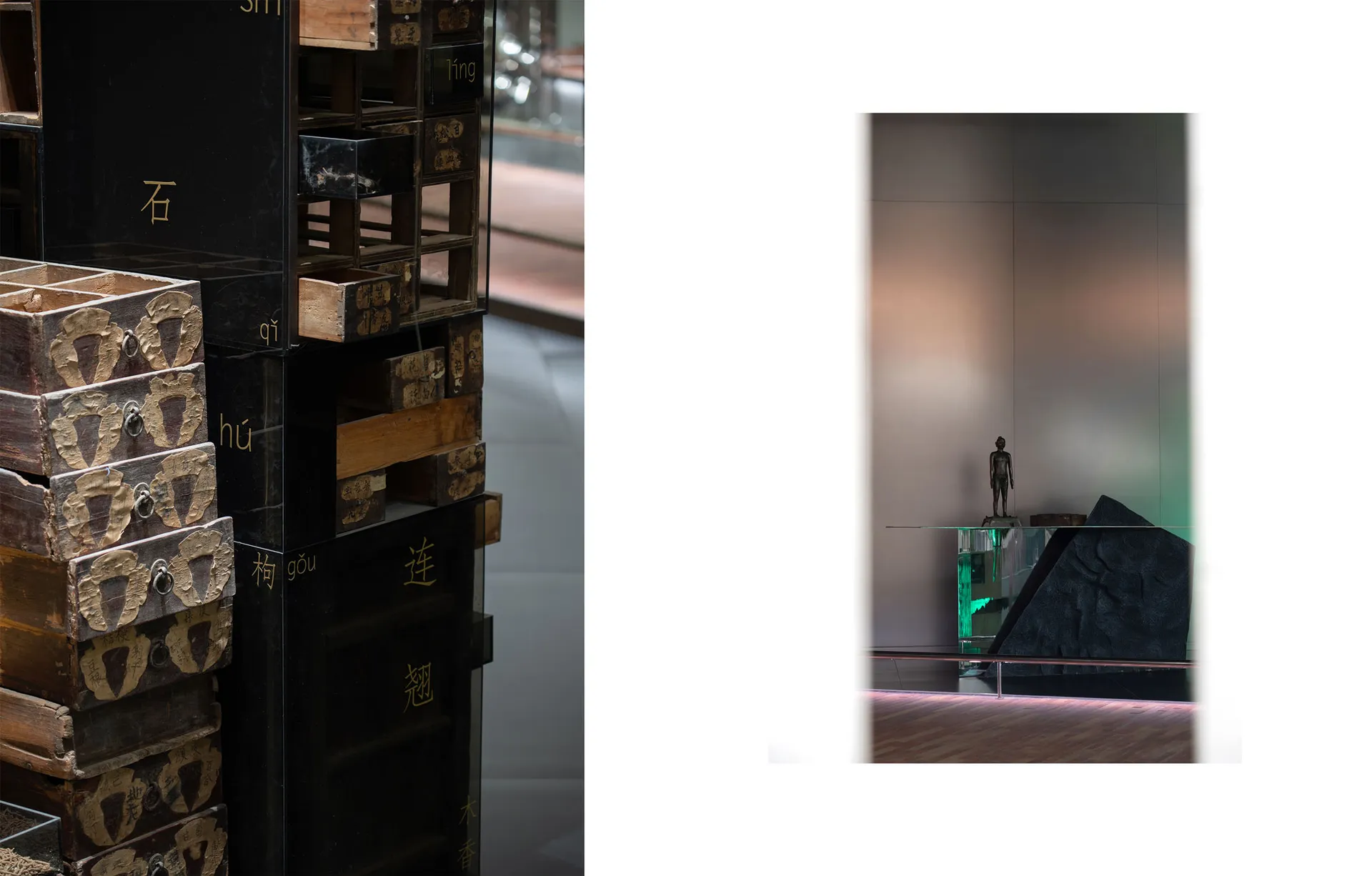 A modern exhibition space featuring wooden crates and a glass table with a green light.