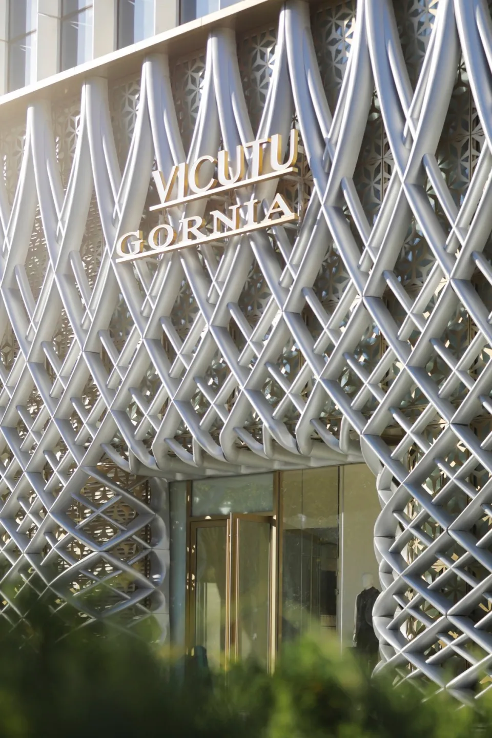 A modern building exterior made of metal with intricate lattice design.