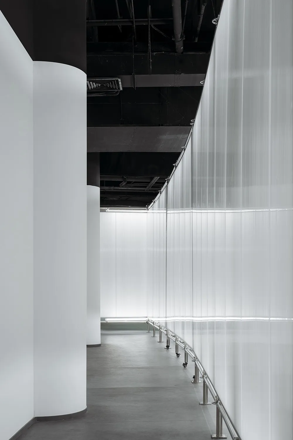 A modern, industrial-style interior space featuring metallic elements and translucent glass panels.