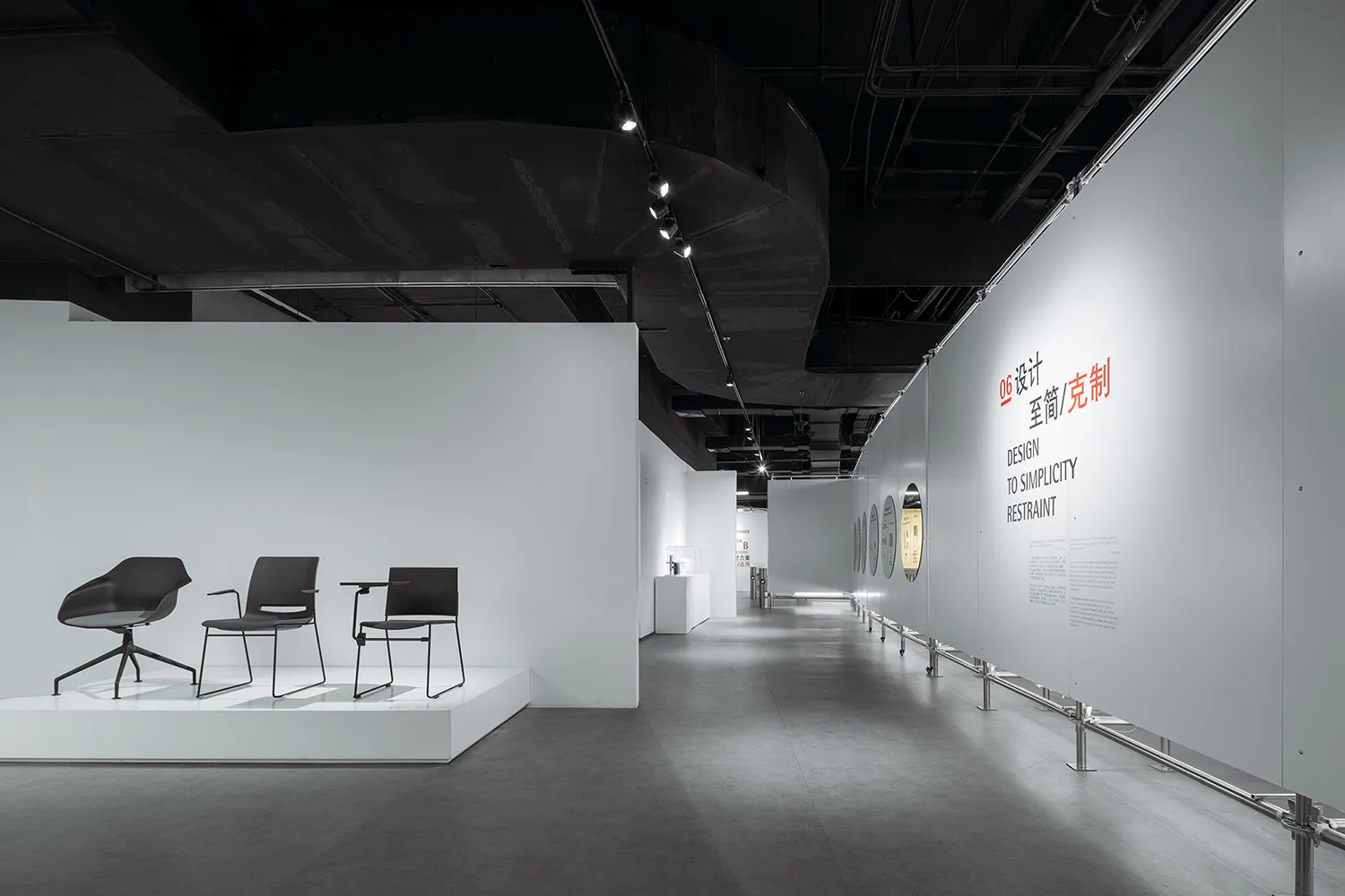 Modern exhibition space with minimalist design, featuring concrete and white materials.
