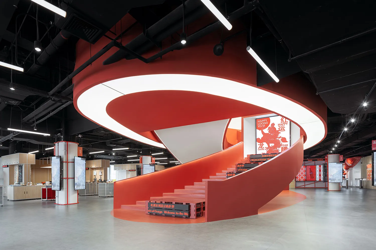 A modern industrial retail space featuring a red concrete spiral staircase with a curved railing.