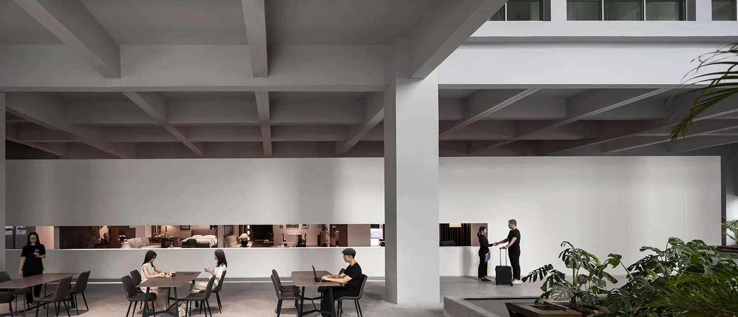 A minimalist co-working space featuring concrete and glass elements.