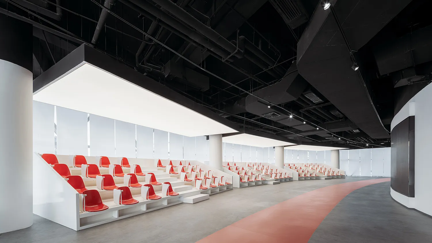 現代活動廳採用混凝土建築,搭配白色座椅與紅色點綴。