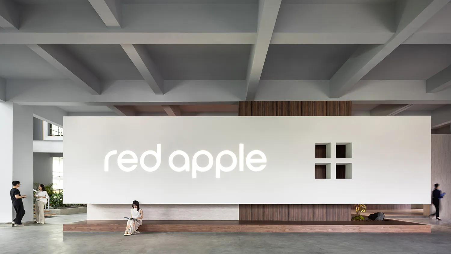 A modern and minimalist office space with white walls and a wooden table.