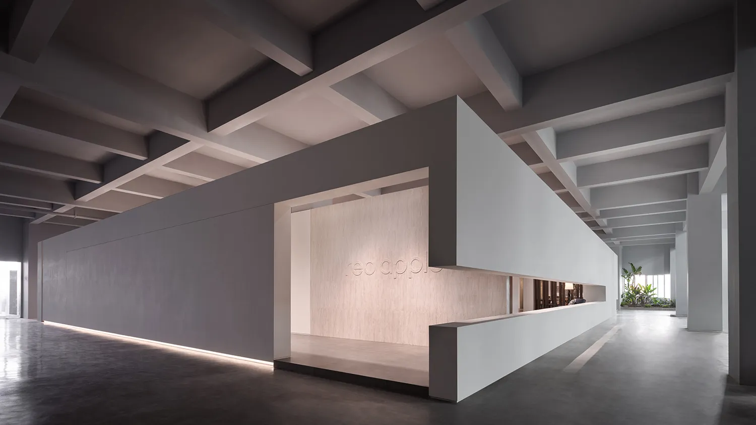 A minimalist office interior featuring a concrete wall and floor.