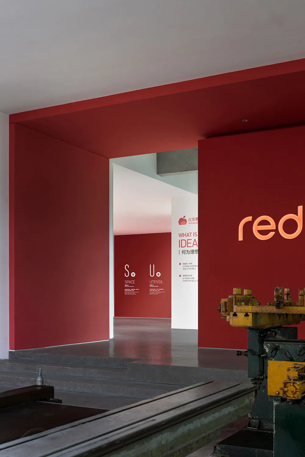 A red exhibition space with metallic elements and industrial design.