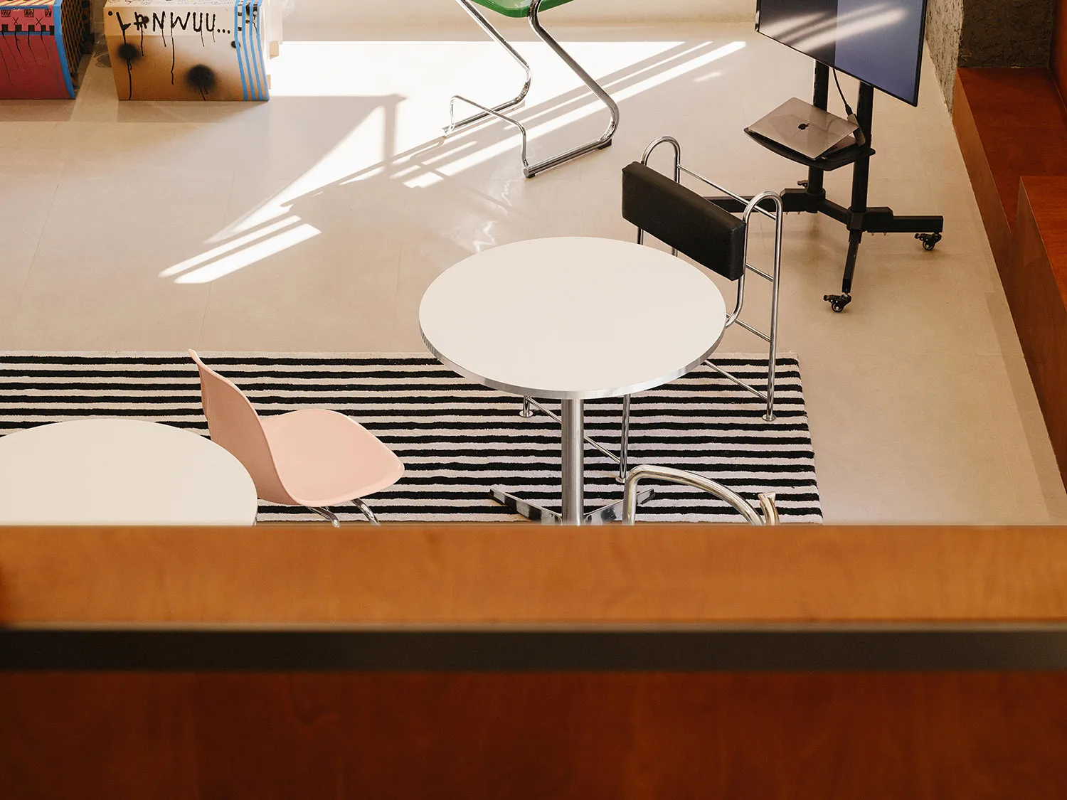 Industrial-style office space featuring a metal table, laminate flooring, and minimalist design.