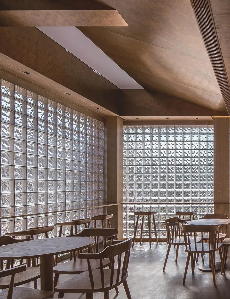 A cozy coffee shop with glass block walls and wooden furniture.