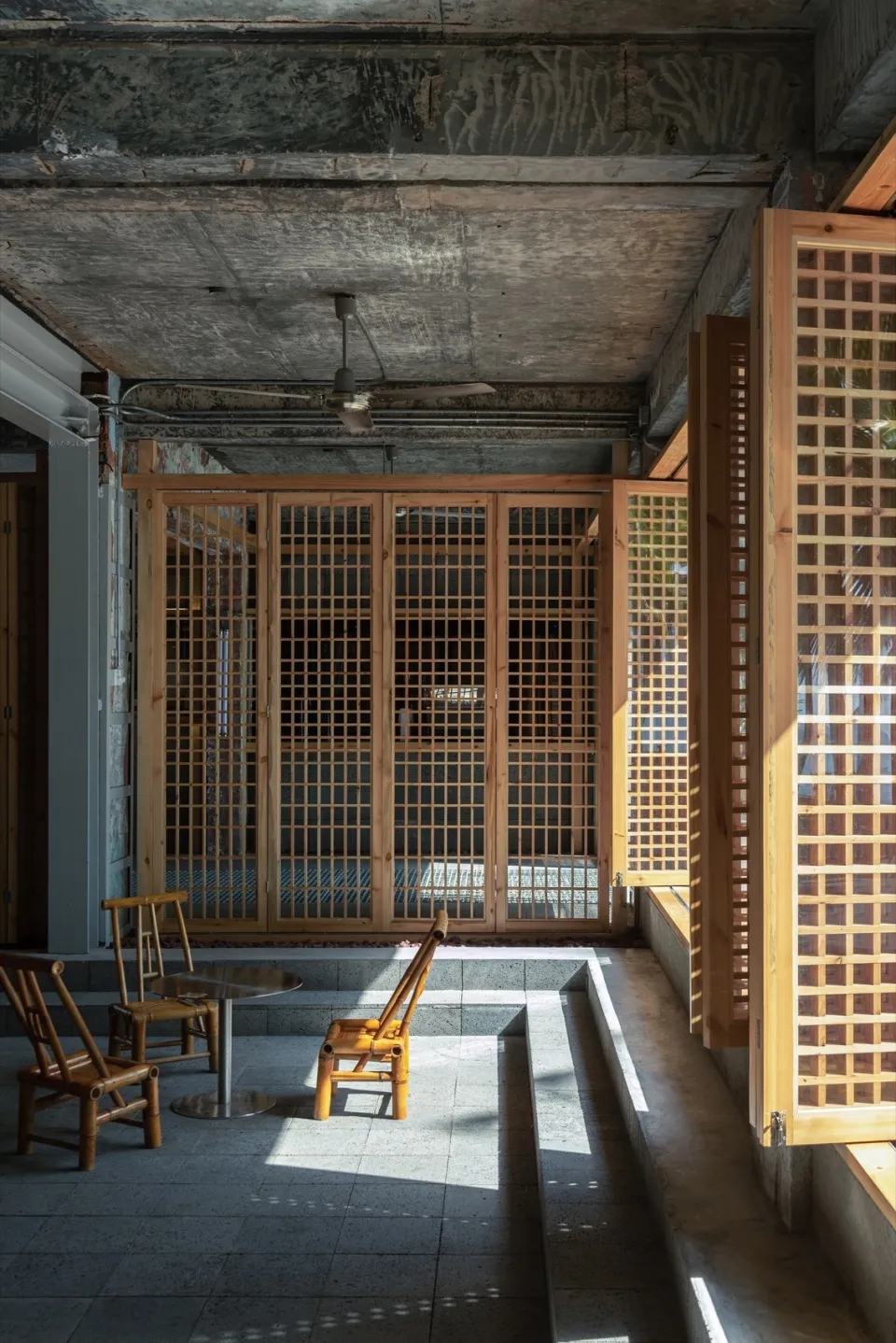 Industrial-style room with wooden grid walls and ceiling fan