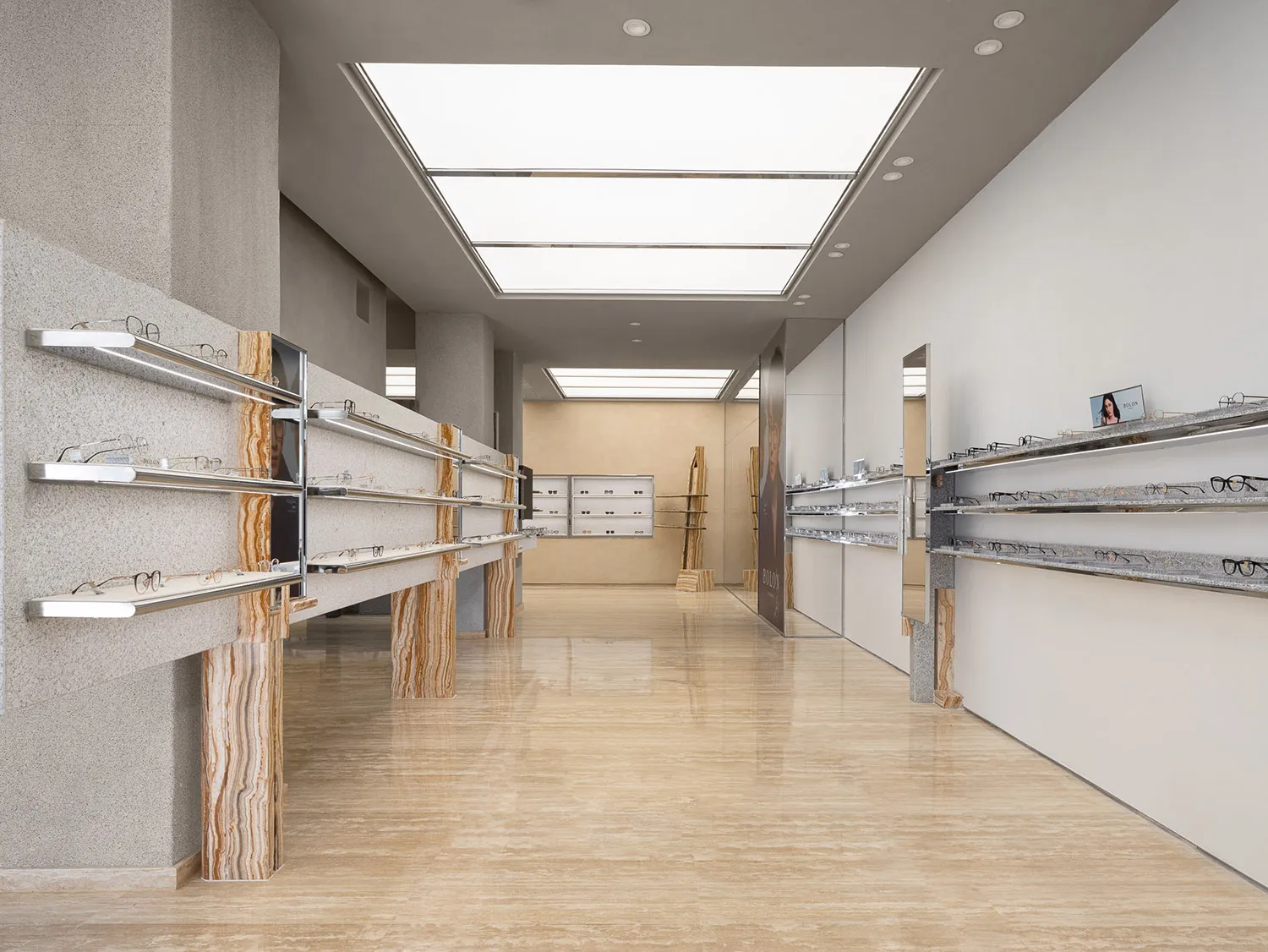 Modern interior of an optical retail store with marble surfaces and sleek, contemporary design.