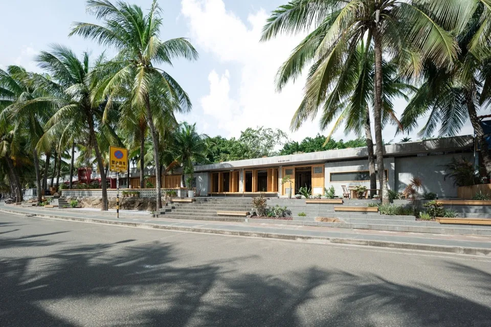 A modern building with concrete exterior surrounded by palm trees.