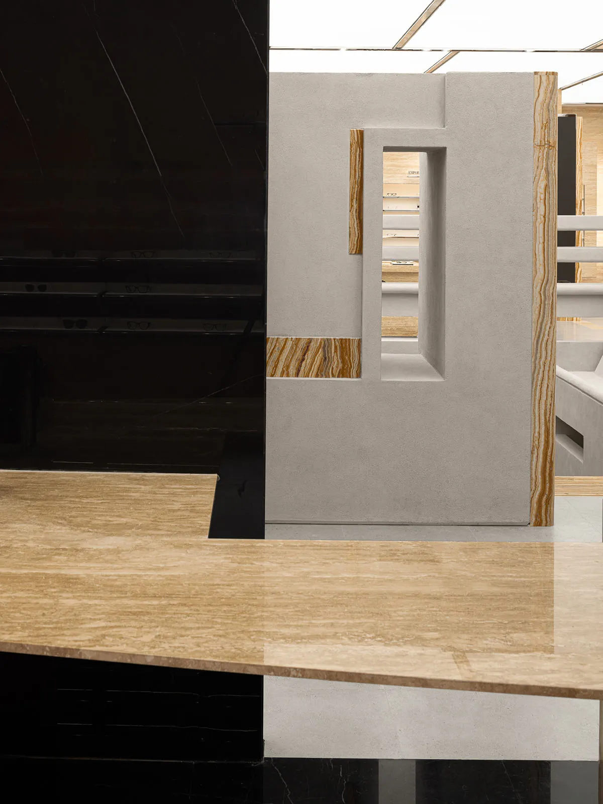A sleek, modern storefront with a glass storefront, concrete elements, and marble accents.