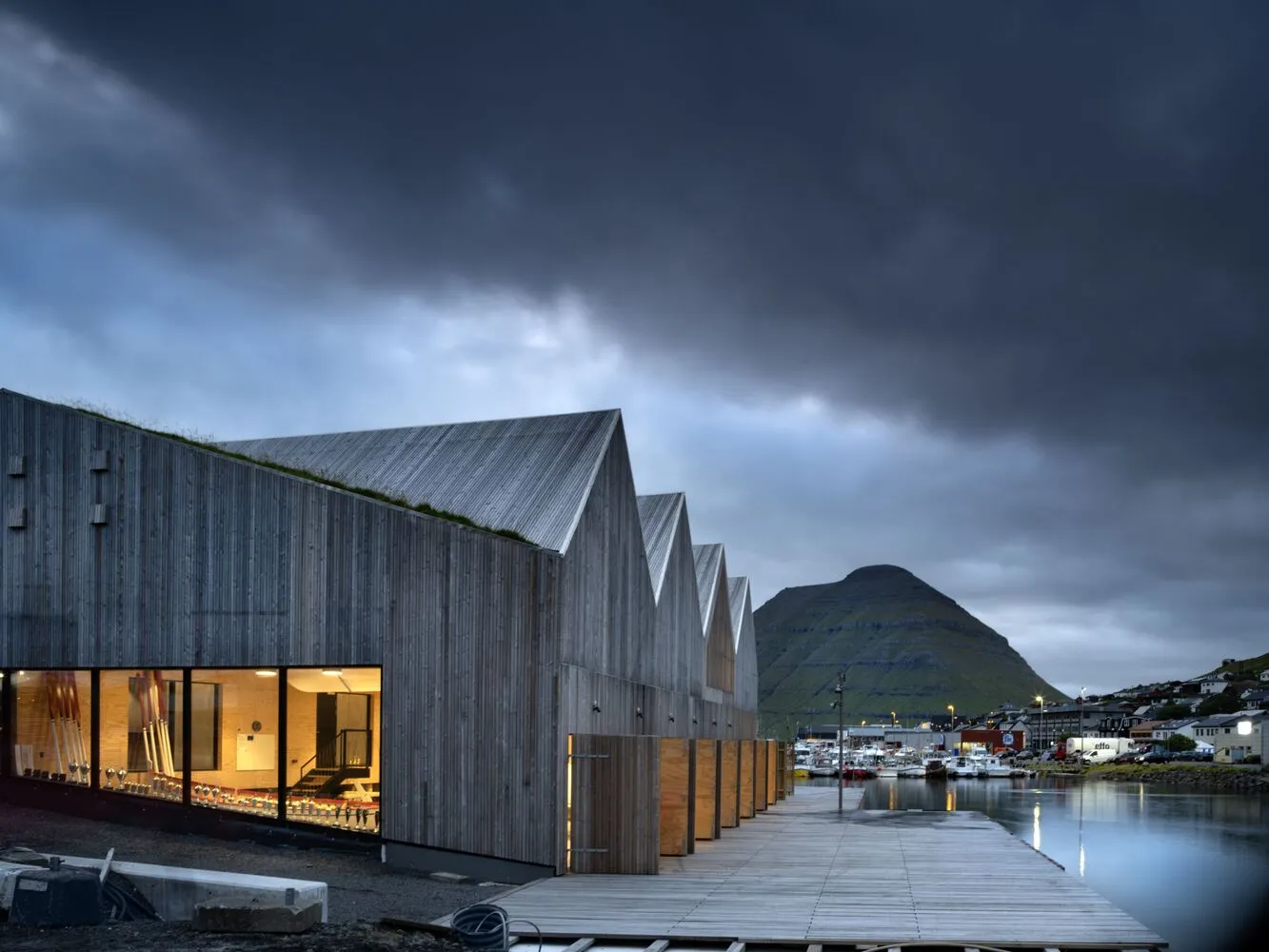 A modern wooden structure with a slanted roof and large windows.