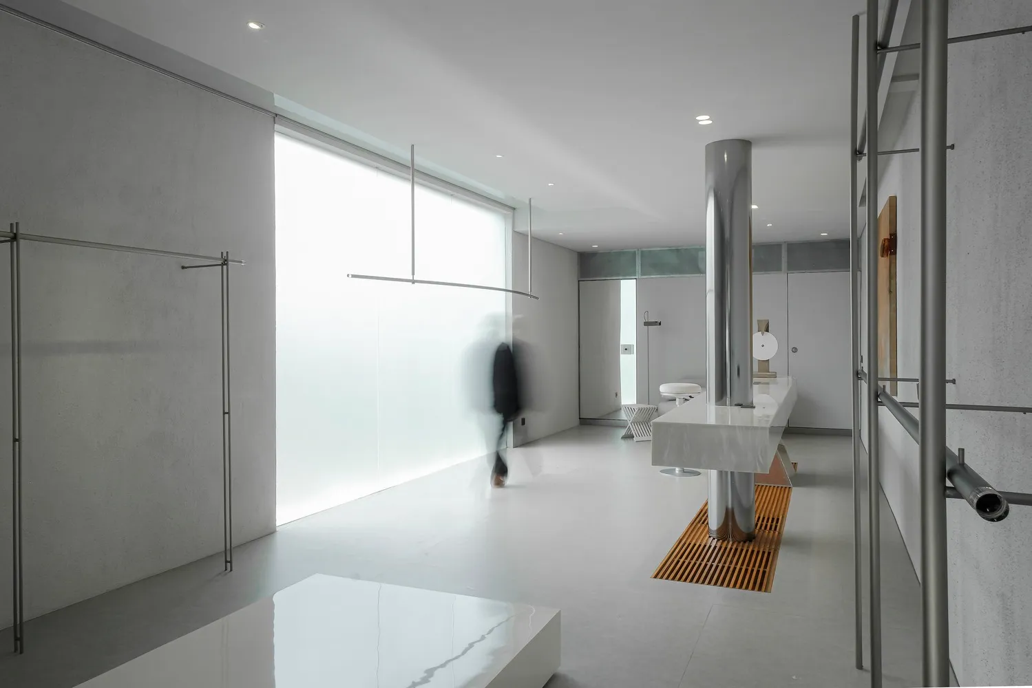 A modern minimalist office space featuring glass and metal elements.