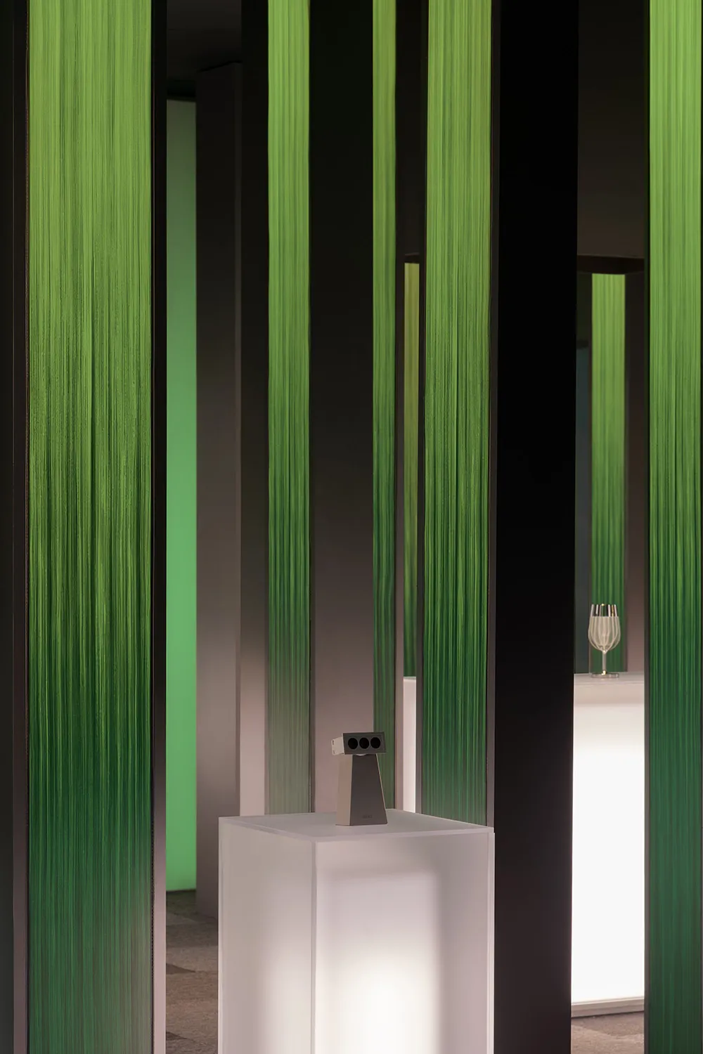 A contemporary art installation featuring modern green columns.
