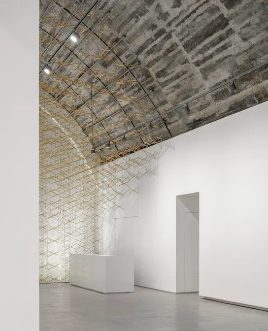 Minimalist art installation featuring metal mesh and concrete