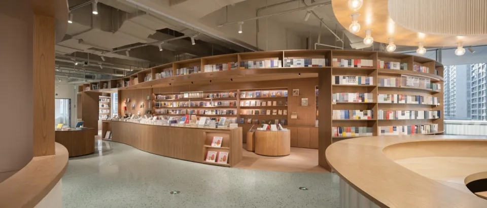 A minimalistic bookstore interior with wooden shelves and displays.