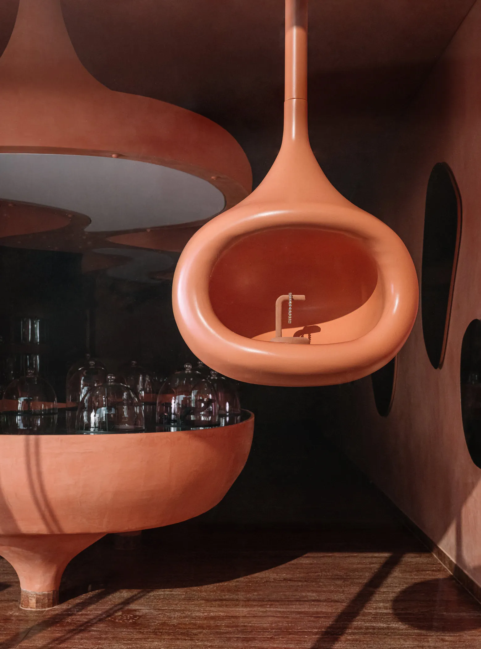 A modern bathroom with a unique, ceramic, suspended sink and bowl ceiling.