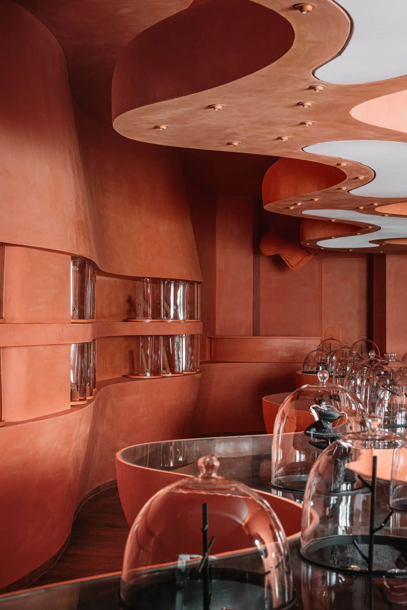 Modern interior design featuring glass and terracotta elements.