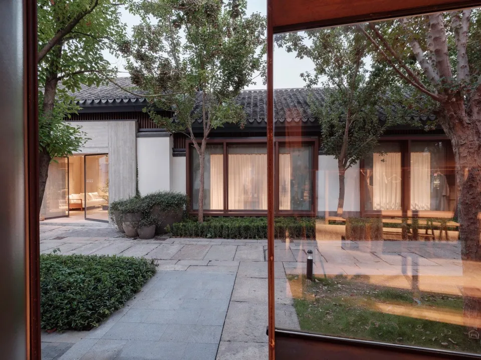 Modern residential space with concrete walls and large glass windows.
