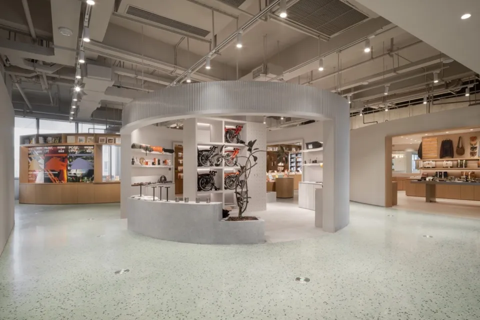 Modern retail boutique showcasing sleek design with concrete flooring and white wall displays.