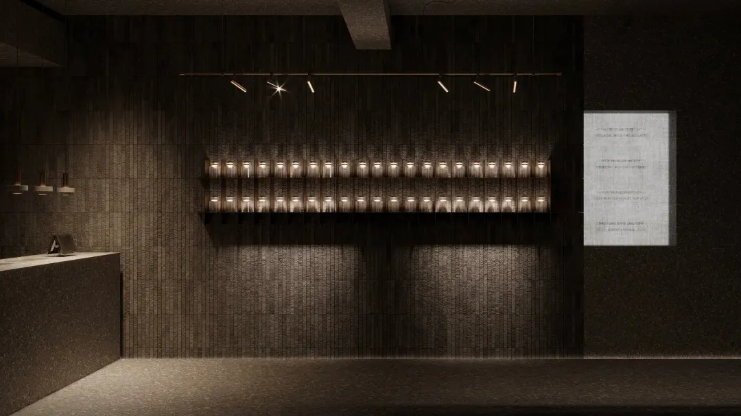 A minimalist industrial exhibition space featuring a brick wall, illuminated by track lighting.