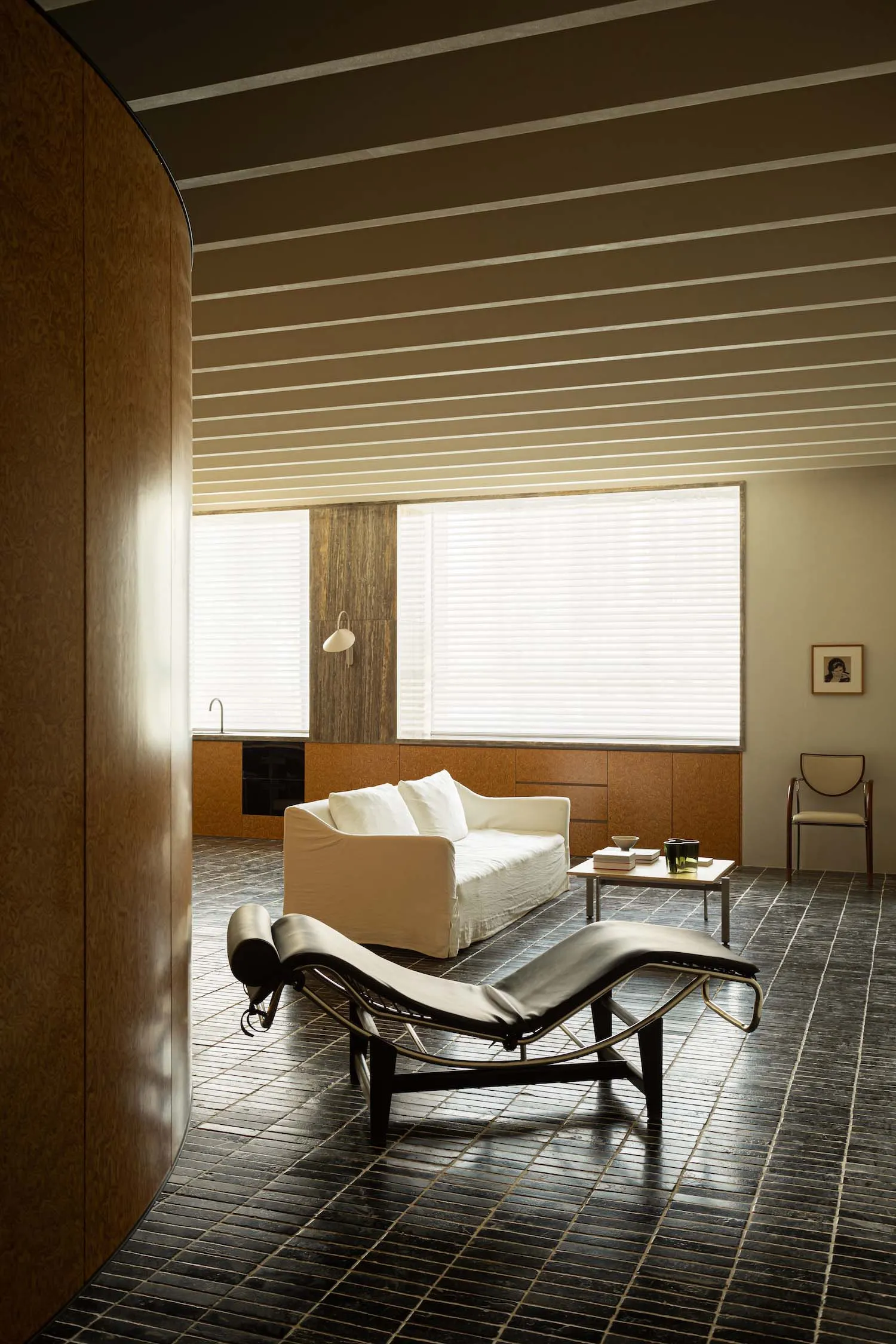 Modern minimalist living room featuring a concrete floor and white furniture.