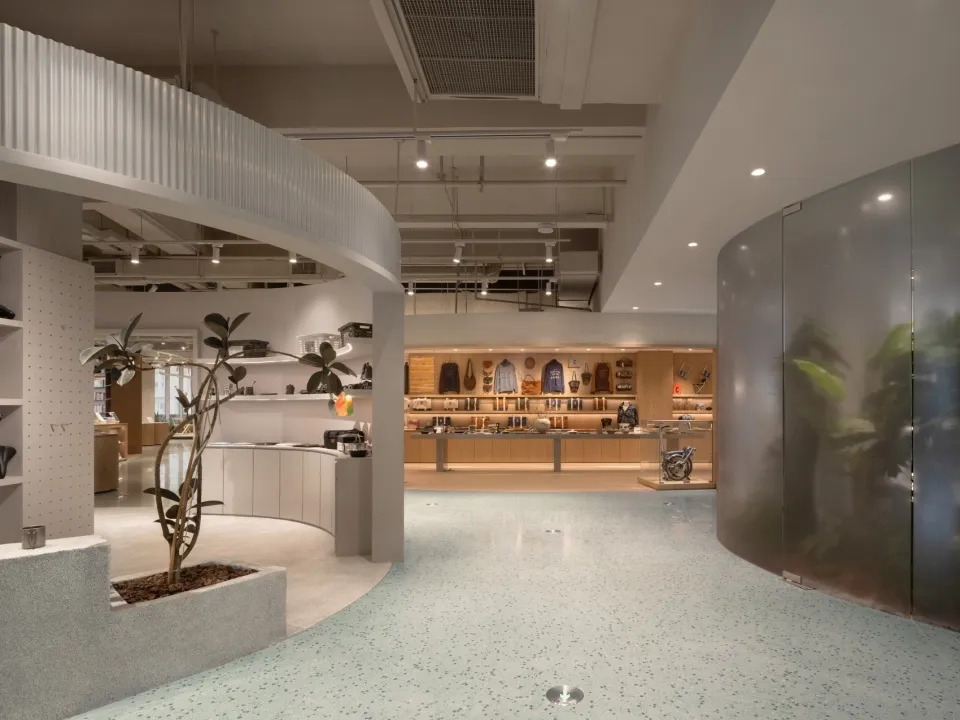 A modern retail store featuring light wood, concrete, and glass materials.