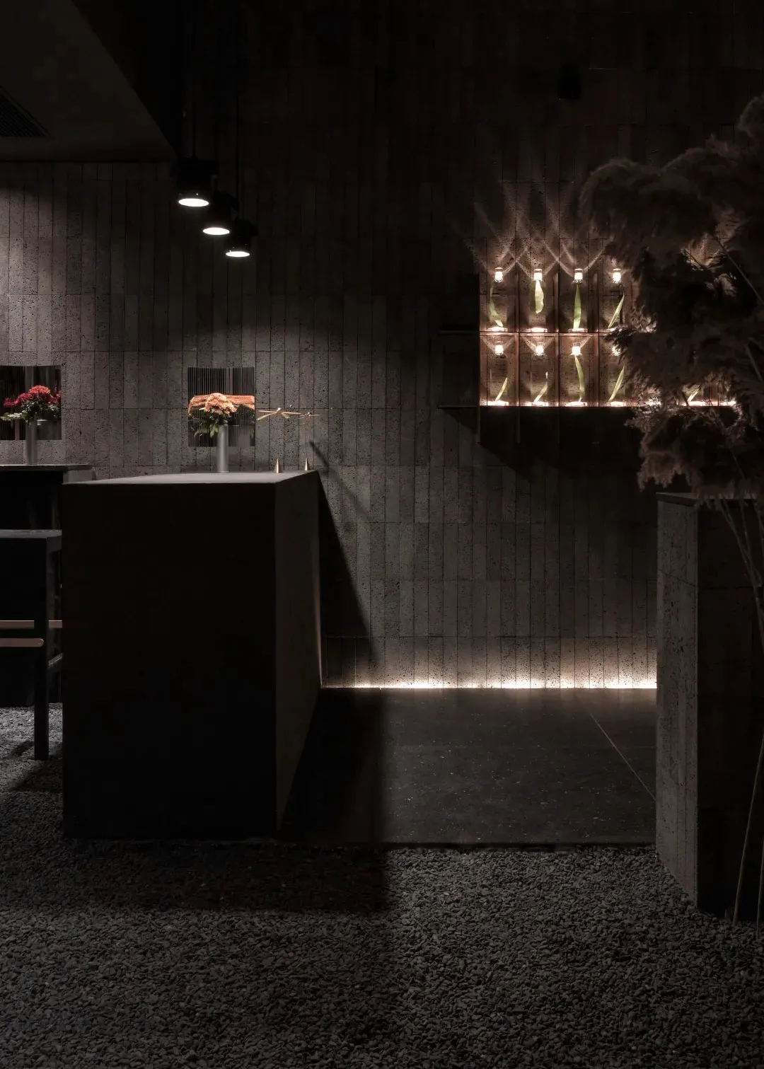 Dark, modern, concrete-themed restaurant-bar interior with minimalist design elements and warm lighting.