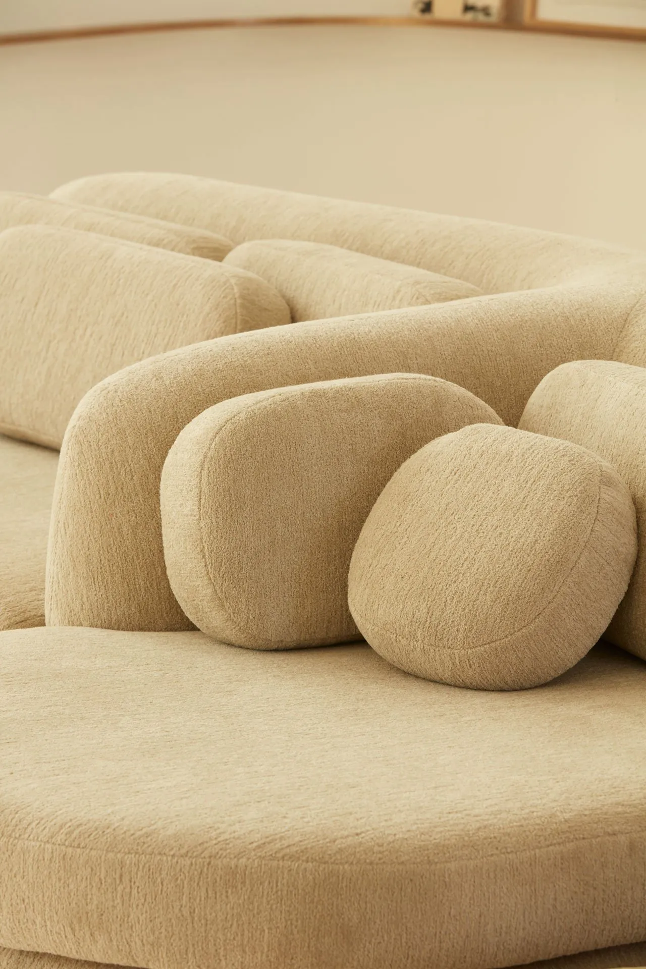 Close-up of a modern, brown fabric sofa with cushioned, rounded components.