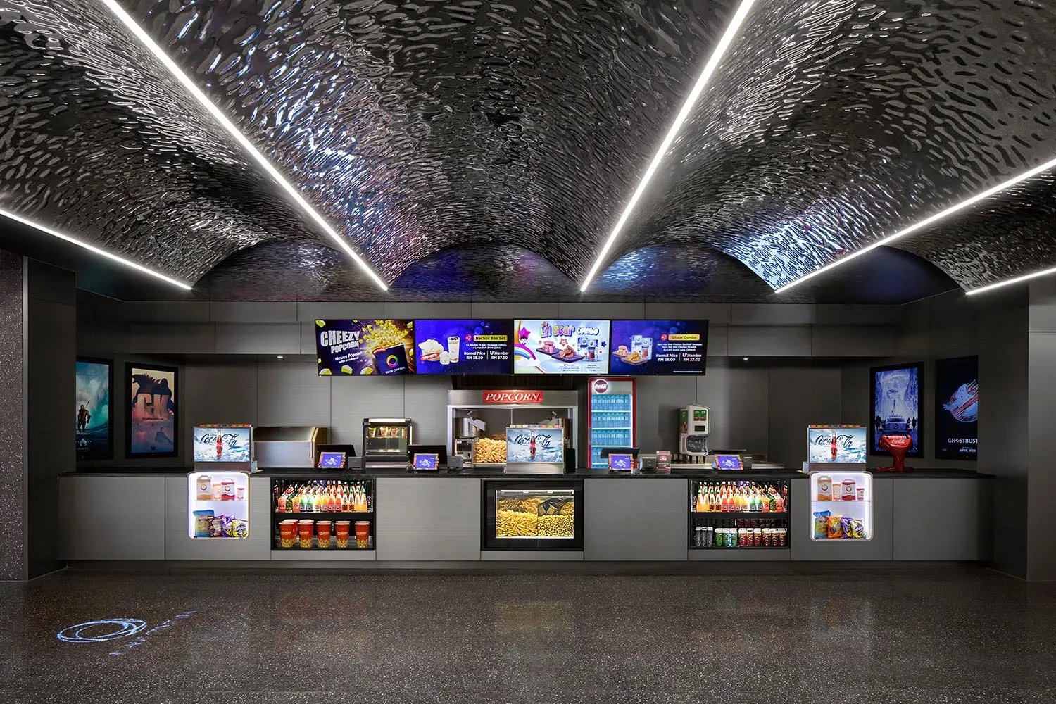 Interior design of a cinema concession stand with metallic texture and concrete materials.