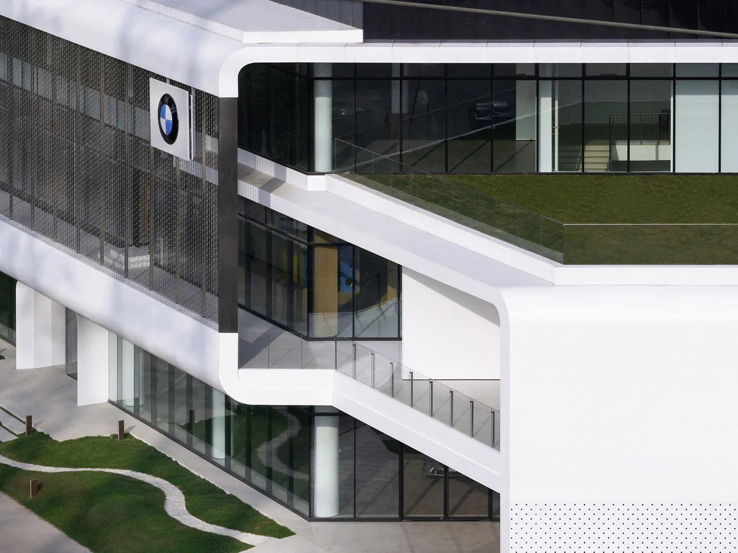 Modern office building with glass walls and metal accents, featuring concrete elements